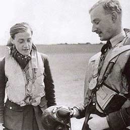 P/O Rupert Smythe shows his 'B' type Flying helmet to F/O Peter Brothers and the damage caused by a German 7.92mm bullet. Now that's what you call a close shave! P/O Rupert Smythe shows his 'B' type Flying helmet to F/O Peter Brothers and the damage caused by a German 7.92mm bullet. Now that's what you call a close shave!